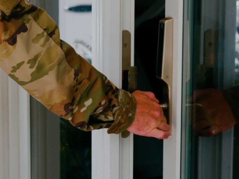 Military person opening home door
