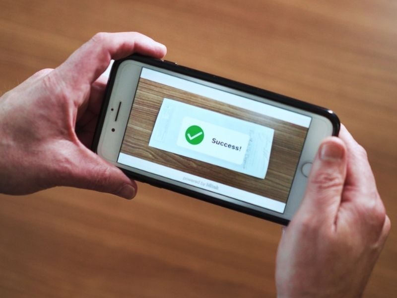 Person taking picture of check for mobile deposit